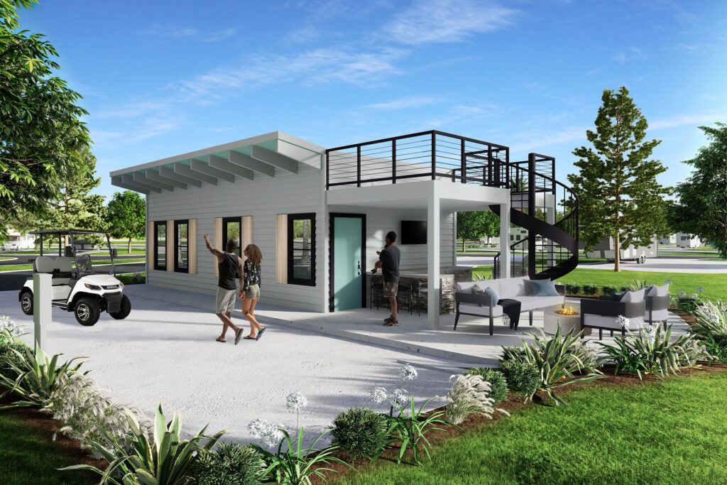 Modern small building in an RV resort with a rooftop terrace accessed by a spiral staircase. A couple is walking towards the building, while another person is standing nearby. The ground level features an outdoor seating area with chairs around a fire pit and a bar counter with stools. A golf cart is parked next to the building. The surroundings include landscaped greenery with various plants and trees, creating a relaxed and inviting atmosphere.